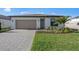 Charming one-story home with brick driveway, two car garage, and well-maintained front lawn at 2327 Candlebrook Path, North Port, FL 34289