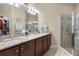 Double vanity bathroom with granite countertop and walk-in shower at 309 Mystic Falls Dr, Apollo Beach, FL 33572