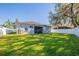 Rear view of a single-story house with a screened patio and AC unit at 35131 Deerfield Oaks Dr, Zephyrhills, FL 33541