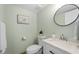 Charming powder room with modern fixtures and a decorative round mirror at 400 64Th Ave # 908, St Pete Beach, FL 33706