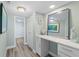 Inviting hallway with wood-look flooring, white cabinets, and a stylish mirror at 400 64Th Ave # 908, St Pete Beach, FL 33706