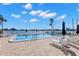 Community pool with lounge chairs, umbrellas, and water views at 400 64Th Ave # 908, St Pete Beach, FL 33706
