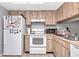 Kitchen with wood cabinets, white appliances, and a refrigerator at 5004 Terrace Palms Cir # 201, Tampa, FL 33617