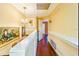 Upstairs hallway with hardwood flooring and white railing overlooking the living area below at 1710 Lighthouse S Ter # 1, South Pasadena, FL 33707