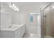 Bright bathroom featuring double sinks, white cabinets, and a glass shower at 2748 Winding Creek Trl, North Port, FL 34289