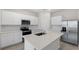 Kitchen with an island, featuring stainless steel appliances, a microwave, oven, and ample storage at 2748 Winding Creek Trl, North Port, FL 34289