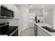 Modern kitchen showcasing stainless steel appliances, white cabinets, and sleek countertops at 2748 Winding Creek Trl, North Port, FL 34289