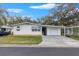 White single-story home with carport and mature landscaping at 34124 Estates Ln, Wesley Chapel, FL 33543