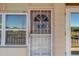 Close-up of the front door featuring decorative security bars and bright natural lighting at 4001 58Th N St # 20, Kenneth City, FL 33709