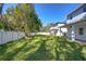 Spacious backyard with grassy lawn, white fence, and large covered patio at 515 Elm St, Safety Harbor, FL 34695