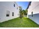 Landscaped backyard with grassy area between two houses at 515 Elm St, Safety Harbor, FL 34695