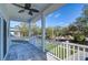 Covered balcony with tile flooring, white railing, and ceiling fan, offering a view of tree-lined street at 515 Elm St, Safety Harbor, FL 34695