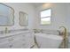 Spa-like bathroom with double vanity, free-standing tub, and gold fixtures at 515 Elm St, Safety Harbor, FL 34695