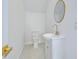 Small, modern bathroom with white vanity, toilet, and a round mirror at 515 Elm St, Safety Harbor, FL 34695