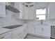 Modern white kitchen with gold hardware, quartz countertops, and stainless steel appliances at 515 Elm St, Safety Harbor, FL 34695