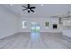 Spacious living area with grey flooring, ceiling fan, and access to backyard at 515 Elm St, Safety Harbor, FL 34695