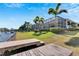 Landscaped backyard with a canal view and a covered patio at 721 Manns Harbor Dr, Apollo Beach, FL 33572