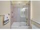 Bathroom featuring a tub with sliding glass door, tiled walls, and modern fixtures at 721 Manns Harbor Dr, Apollo Beach, FL 33572