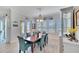 Bright dining room featuring a wood table, teal chairs, and plantation shutters at 721 Manns Harbor Dr, Apollo Beach, FL 33572