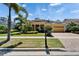 Charming yellow home with lush landscaping, brick driveway, and a well-maintained front lawn at 721 Manns Harbor Dr, Apollo Beach, FL 33572