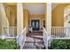 Covered front porch with white railings and double entry doors at 721 Manns Harbor Dr, Apollo Beach, FL 33572