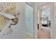 Hallway with a decorative peacock wall art and access to bedrooms at 721 Manns Harbor Dr, Apollo Beach, FL 33572