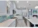 Modern kitchen with white cabinets, quartz countertops, and teal backsplash at 721 Manns Harbor Dr, Apollo Beach, FL 33572