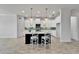 Stylish kitchen with white cabinets, black island, tiled backsplash, and modern lighting at 721 Manns Harbor Dr, Apollo Beach, FL 33572
