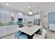 Modern white kitchen with a large island, stainless steel appliances, and teal accents at 721 Manns Harbor Dr, Apollo Beach, FL 33572