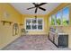 Covered lanai featuring brick pavers, ceiling fan, grill and bright yellow walls at 721 Manns Harbor Dr, Apollo Beach, FL 33572