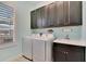 Laundry room with white washer and dryer, dark cabinets, and a sink at 721 Manns Harbor Dr, Apollo Beach, FL 33572
