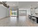 Open living area with wood-look tile floors, fan, and sliding glass doors to the pool at 721 Manns Harbor Dr, Apollo Beach, FL 33572