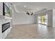 Bright living room featuring modern fireplace and sliding glass doors to outdoor pool at 721 Manns Harbor Dr, Apollo Beach, FL 33572