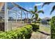 Screened lanai featuring a waterfront view and access to the canal, complemented by lush landscaping and a charming dock at 721 Manns Harbor Dr, Apollo Beach, FL 33572
