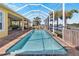 Long rectangular pool with a screened enclosure and waterfront view at 721 Manns Harbor Dr, Apollo Beach, FL 33572