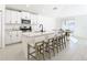 Modern kitchen with white cabinets, quartz countertops, and island seating at 8849 Little Bluestem Dr, Land O Lakes, FL 34637