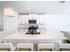 Modern kitchen with white cabinets, quartz countertops and island at 8849 Little Bluestem Dr, Land O Lakes, FL 34637