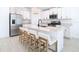 Modern kitchen with white cabinets, quartz countertops, and island seating at 8849 Little Bluestem Dr, Land O Lakes, FL 34637