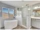 Spa-like bathroom featuring a soaking tub, walk-in shower, and window at 11217 Avery Oaks Dr, Tampa, FL 33625