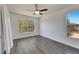 Bedroom with wood-look floors, ceiling fan, and large window with garden view at 11217 Avery Oaks Dr, Tampa, FL 33625