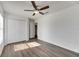 Spacious bedroom featuring wood-look floors, ceiling fan, and access to bathroom at 11217 Avery Oaks Dr, Tampa, FL 33625