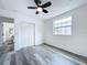 Bright bedroom with ceiling fan, window, and grey wood-look floors at 2310 W Ivy St, Tampa, FL 33607