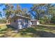 Newly renovated house exterior, featuring gray siding and a spacious yard at 26237 Blackjack St, Brooksville, FL 34601