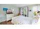 Bedroom with white bed frame, colorful bedding, and access to patio at 4925 38Th S Way # A104, St Petersburg, FL 33711