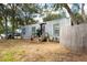 Gray shipping container home with wooden fence and landscaping at 5021 69Th N Way, St Petersburg, FL 33709