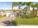 House exterior featuring a two-car garage and palm trees at 5124 Highland Pointe Ct, Wimauma, FL 33598