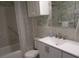 Bathroom with updated vanity, tiled shower, and decorative wallpaper at 6000 20Th N St # 114, St Petersburg, FL 33714