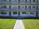 Front view of a two-story building with multiple balconies and a well-maintained lawn at 6000 20Th N St # 114, St Petersburg, FL 33714