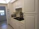 View of kitchen with white cabinets, gas cooktop, and built-in oven at 6000 20Th N St # 114, St Petersburg, FL 33714
