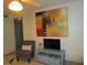 Living room featuring a large abstract painting, TV, and comfy armchair at 6000 20Th N St # 114, St Petersburg, FL 33714